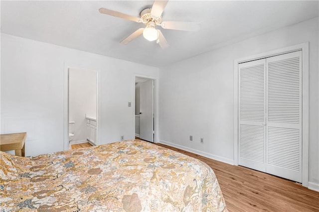 bedroom featuring wood finished floors, a closet, ensuite bath, and ceiling fan