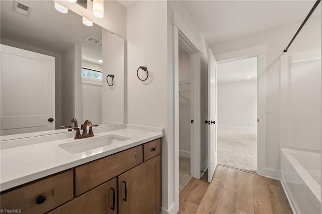 7815 Michaelis St, Greensboro, NC 27455 - full bathroom featuring wood finished floors, vanity, shower / tub combination, and a spacious closet