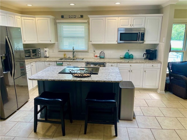 940 Huntington Run Ln, Kernersville, NC 27284 - kitchen with stainless steel appliances, a sink, crown molding, a kitchen bar, and white cabinets