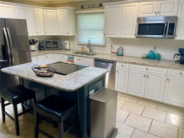 940 Huntington Run Ln, Kernersville, NC 27284 - kitchen featuring stainless steel appliances, a sink, a kitchen bar, and white cabinetry