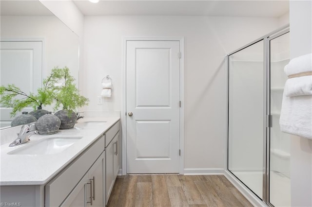 bathroom with a shower with door, vanity, and hardwood / wood-style flooring