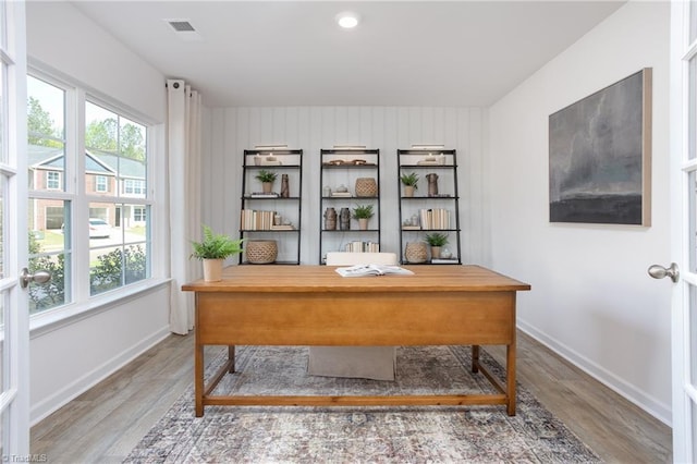 office area with plenty of natural light and hardwood / wood-style flooring