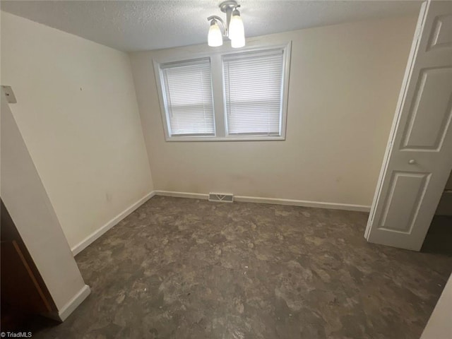 unfurnished room featuring a textured ceiling