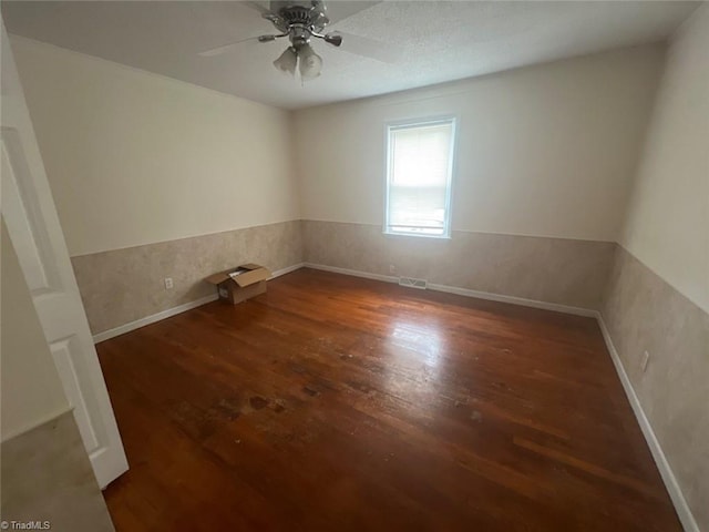 unfurnished room featuring ceiling fan and dark hardwood / wood-style flooring