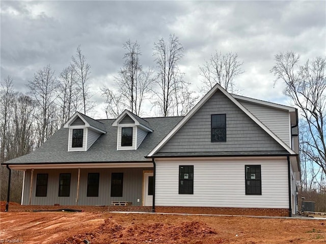 view of front facade with covered porch and roof with shingles