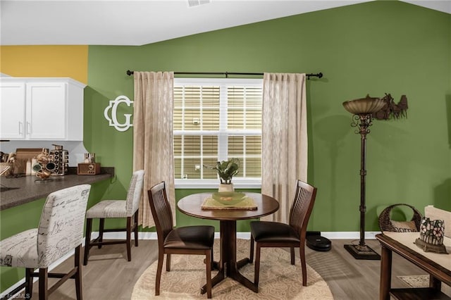 1009 Cannonade Dr, Whitsett, NC 27377 - dining space with lofted ceiling, light wood-style flooring, and baseboards