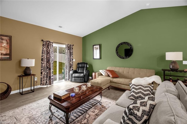 1009 Cannonade Dr, Whitsett, NC 27377 - living area with wood finished floors, lofted ceiling, and baseboards