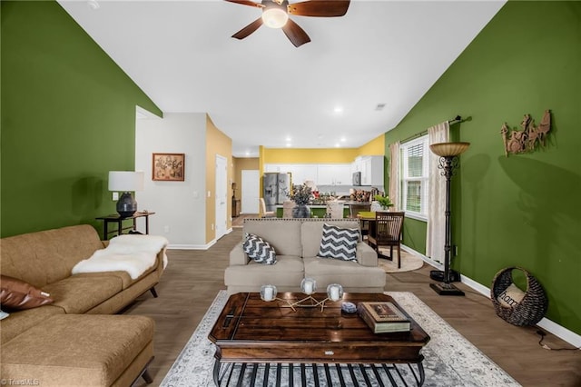 1009 Cannonade Dr, Whitsett, NC 27377 - living area with lofted ceiling, baseboards, a ceiling fan, and dark wood-style floors