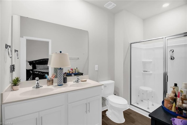 1009 Cannonade Dr, Whitsett, NC 27377 - full bath featuring double vanity, a stall shower, toilet, and wood finished floors
