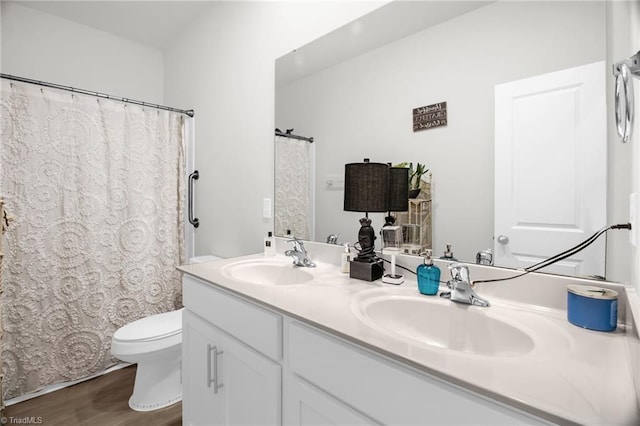 1009 Cannonade Dr, Whitsett, NC 27377 - full bath featuring toilet, double vanity, wood finished floors, and curtained shower