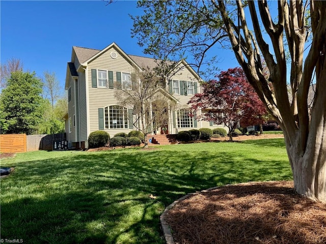 traditional-style home featuring fence and a front lawn