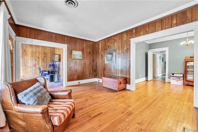 1112 Hamilton St, High Point, NC 27262 - living area featuring ornamental molding, a chandelier, wooden walls, and light wood-type flooring