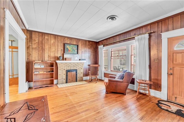 1112 Hamilton St, High Point, NC 27262 - living room featuring ornamental molding, plenty of natural light, hardwood / wood-style floors, wood walls, and a fireplace