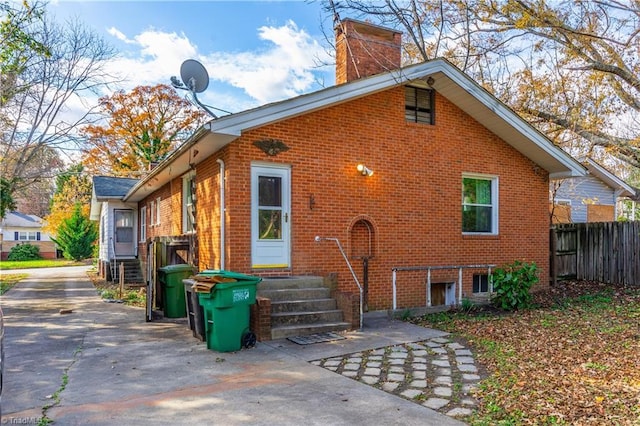 1112 Hamilton St, High Point, NC 27262 - view of side of property with entry steps, brick siding, and a chimney