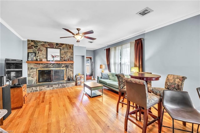 1112 Hamilton St, High Point, NC 27262 - living room with ornamental molding, a ceiling fan, a fireplace, and light wood-type flooring