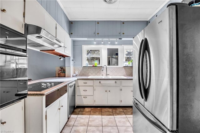 1112 Hamilton St, High Point, NC 27262 - kitchen with black appliances, under cabinet range hood, decorative backsplash, light tile patterned floors, and white cabinetry
