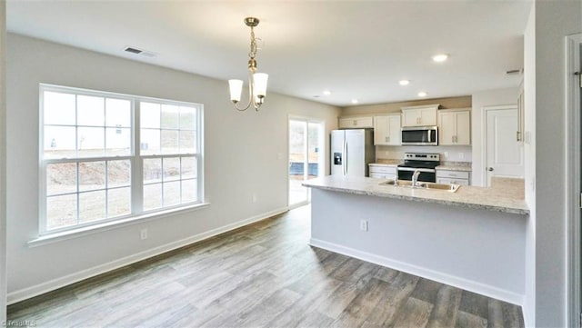 kitchen with dark wood-style floors, stainless steel appliances, a sink, and a healthy amount of sunlight