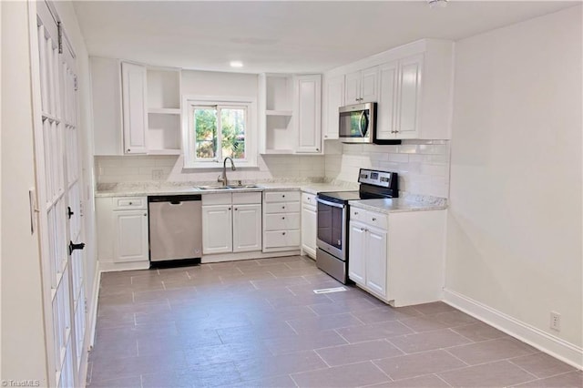 kitchen with white cabinets, appliances with stainless steel finishes, tasteful backsplash, and sink