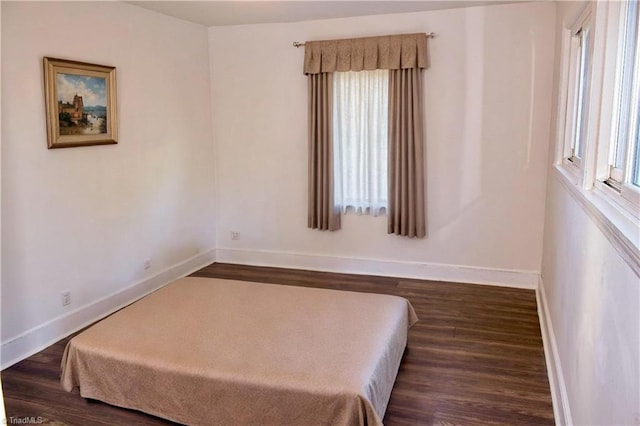 bedroom with dark wood-type flooring