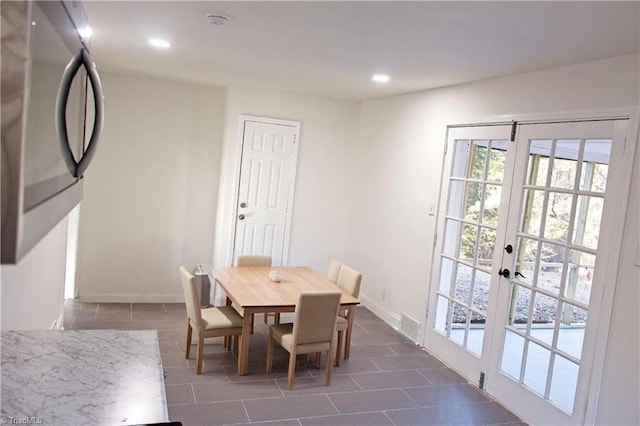 dining room with french doors and dark tile patterned flooring