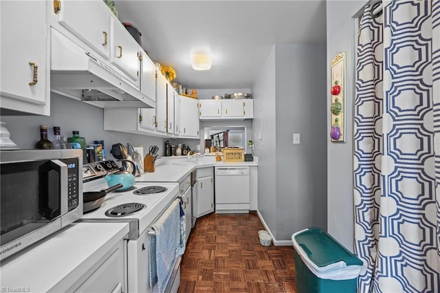 217 Village Ln Unit G, Greensboro, NC 27409 - kitchen featuring white appliances, light countertops, under cabinet range hood, white cabinetry, and baseboards