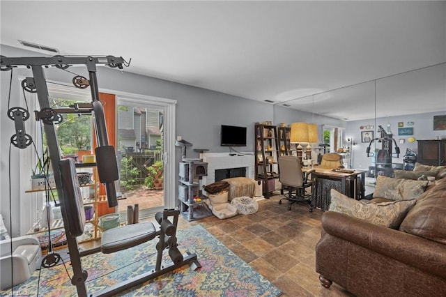 217 Village Ln Unit G, Greensboro, NC 27409 - living area with stone finish floors, healthy amount of natural light, and a brick fireplace
