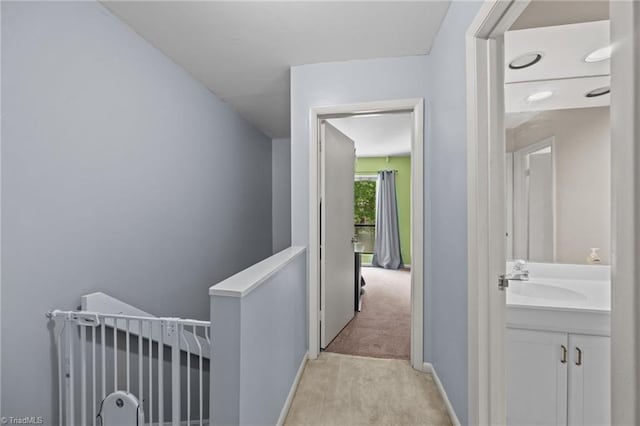 217 Village Ln Unit G, Greensboro, NC 27409 - corridor with an upstairs landing, a sink, light colored carpet, and baseboards