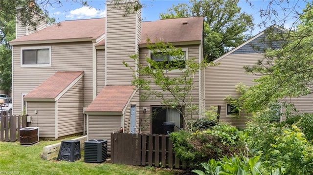 217 Village Ln Unit G, Greensboro, NC 27409 - rear view of property with cooling unit and a chimney