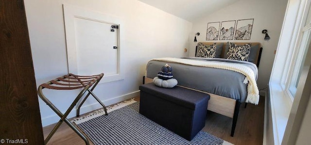 bedroom with lofted ceiling and hardwood / wood-style floors