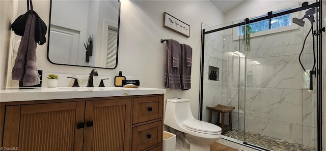 bathroom with a shower with shower door, toilet, and vanity