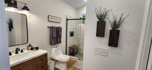 bathroom with wood-type flooring, toilet, walk in shower, and vanity