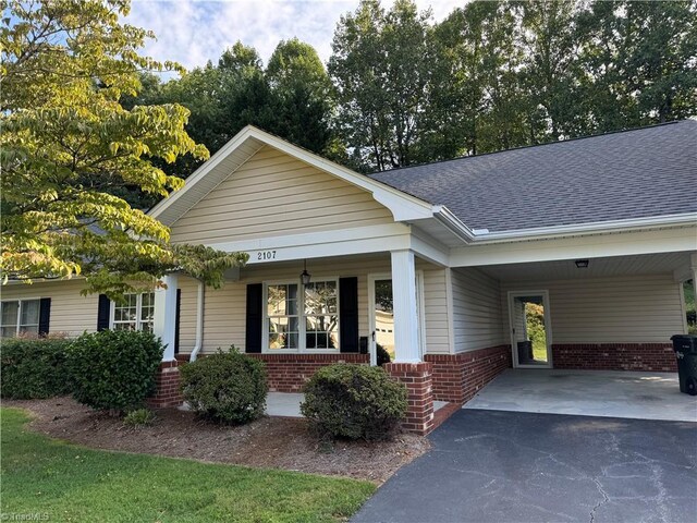 view of front of property featuring a porch and a carport