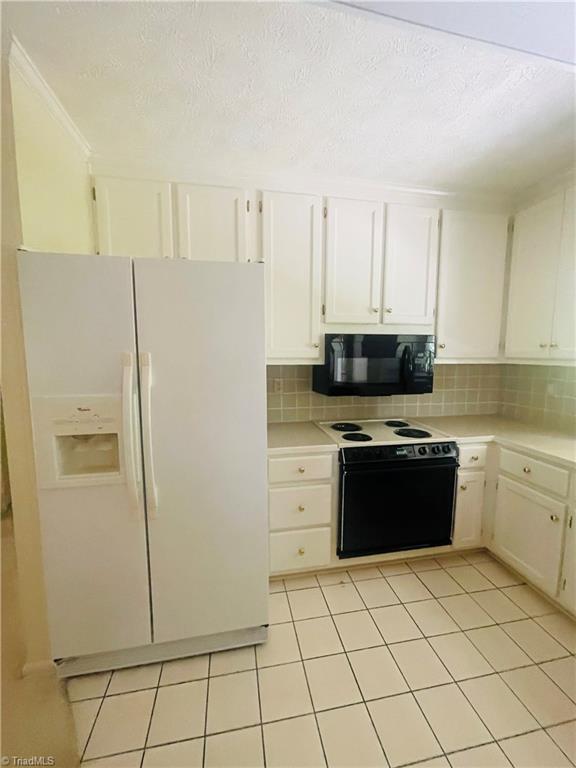 kitchen featuring light tile patterned flooring, white cabinetry, white appliances, and decorative backsplash