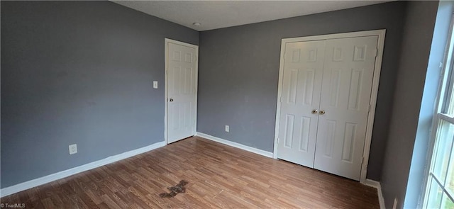 unfurnished bedroom featuring hardwood / wood-style floors and a closet