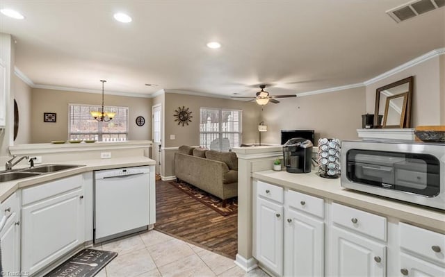 kitchen featuring a sink, visible vents, open floor plan, dishwasher, and crown molding