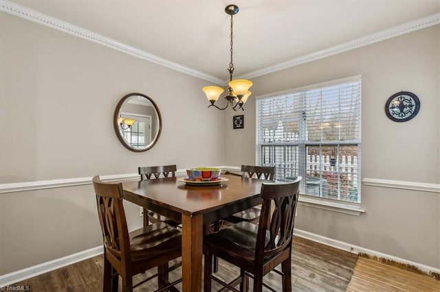 dining area with crown molding, a notable chandelier, wood finished floors, and baseboards