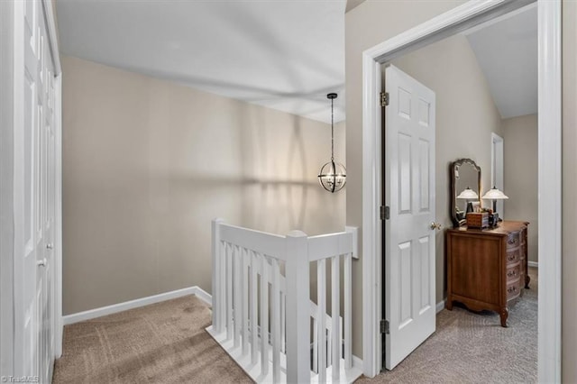 interior space featuring a chandelier, carpet, a crib, and baseboards