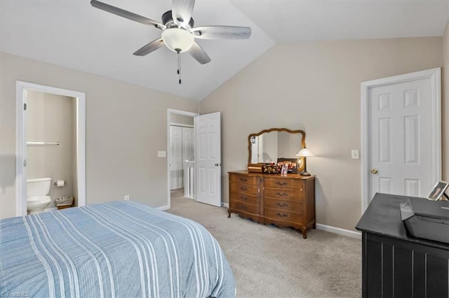 bedroom featuring baseboards, light colored carpet, lofted ceiling, ceiling fan, and ensuite bathroom