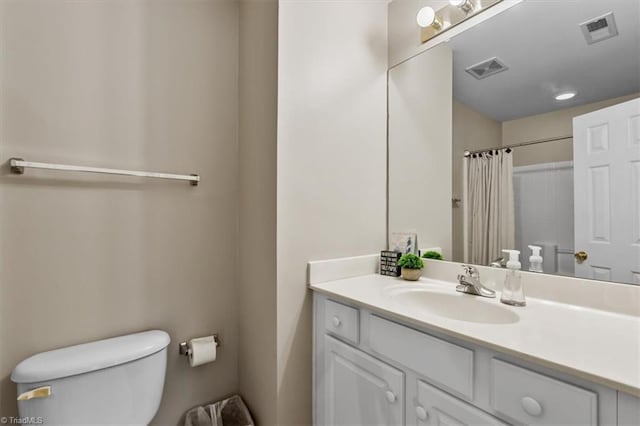 bathroom featuring toilet, curtained shower, vanity, and visible vents