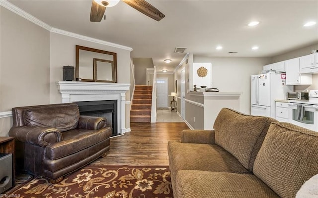 living area featuring dark wood-style flooring, crown molding, a fireplace, recessed lighting, and visible vents