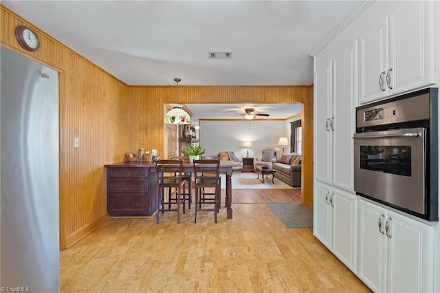 kitchen featuring white cabinets, decorative light fixtures, ceiling fan, and stainless steel appliances