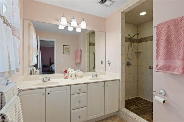 bathroom with vanity and a tile shower