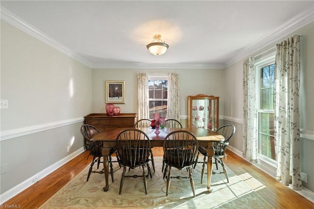 dining room with light hardwood / wood-style floors and ornamental molding