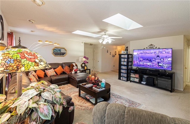 carpeted living room featuring ceiling fan, a textured ceiling, and a skylight