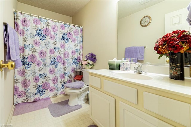 bathroom with a textured ceiling, toilet, and vanity