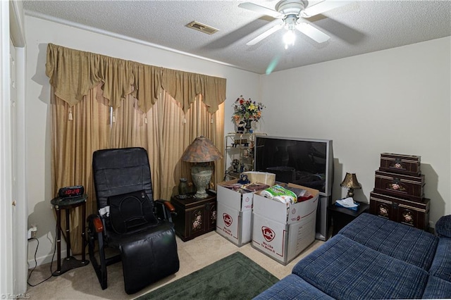 bedroom with ceiling fan, a textured ceiling, and light carpet