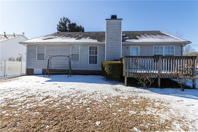 snow covered house with a deck