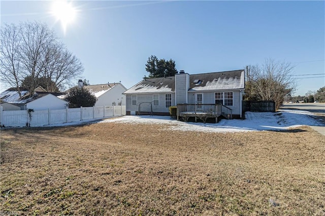 rear view of house featuring a deck and a yard