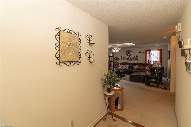 hall with a textured ceiling and carpet floors