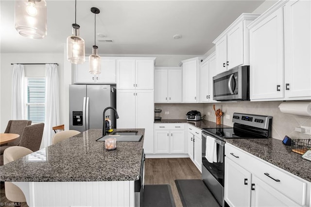 4062 Monteray Cir, High Point, NC 27265 - kitchen with appliances with stainless steel finishes, a sink, dark wood-style floors, a kitchen island with sink, and white cabinetry